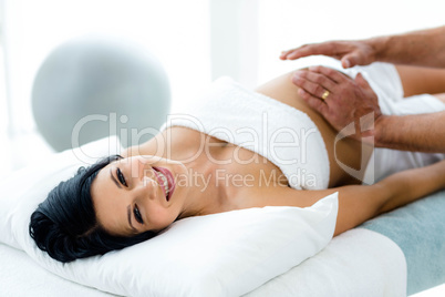 Pregnant woman receiving a stomach massage from masseur