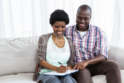 Pregnant couple writing on a notepad
