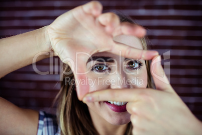 Pretty blonde woman looking through her hands
