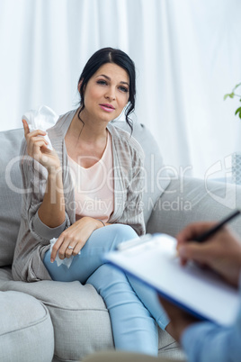 Doctor writing on clipboard while consulting pregnant woman