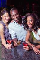 Portrait of young friends having drinks at bar counter