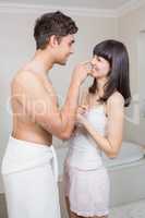 Man applying moisturizer on womans nose