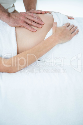 Pregnant woman receiving a stomach massage from masseur