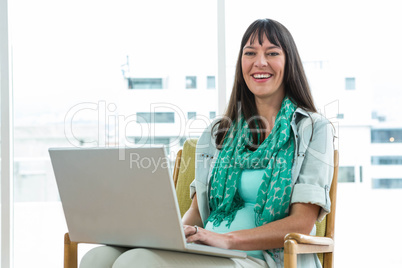 Pregnant woman using laptop