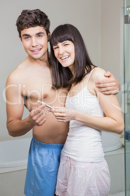Happy couple checking results of pregnancy test