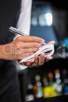 Bartender writing down an order