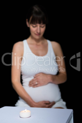 Pregnant woman and glass on table