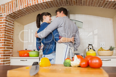 Vegetables on chopping board and couple embracing