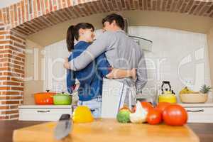 Vegetables on chopping board and couple embracing