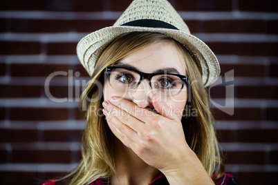 Pretty blonde woman covering her mouth with her hand