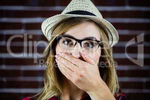 Pretty blonde woman covering her mouth with her hand