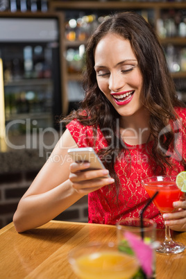 Pretty woman taking a selfie with her cocktail