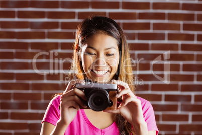 Smiling asian woman taking picture with camera