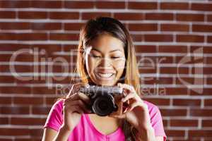 Smiling asian woman taking picture with camera