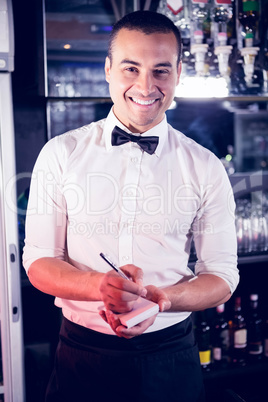 Portrait of a waiter writing down an order