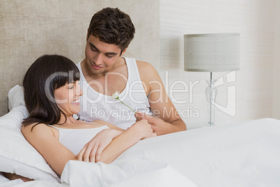 Man offering a flower to woman