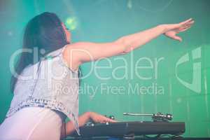 Female DJ waving her hand while playing music