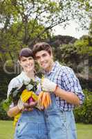 Young couple holding freshly harvested vegetables
