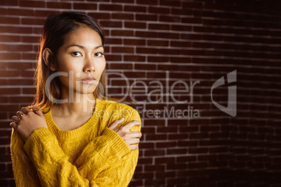 Serious asian woman with hands on shoulders