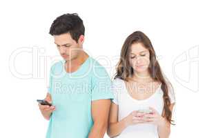 Concentrated couple using their smartphones