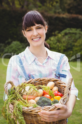 Woman holding a basket of freshly harvested vegetables