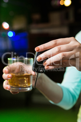 Woman holding a glass of whiskey and car keys