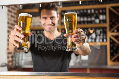 Handsome barman holding a pint of beer