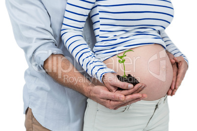 Pregnant couple holding sapling