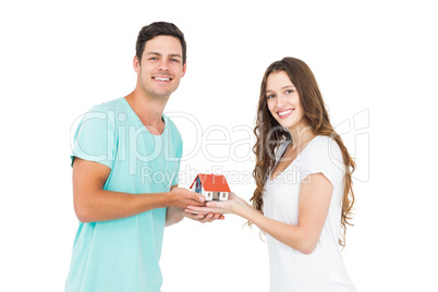 Happy couple holding miniature house