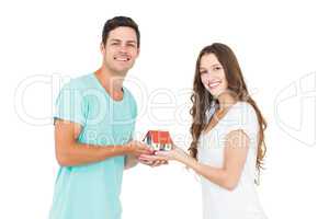 Happy couple holding miniature house