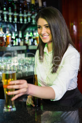 Pretty bartender serving beer at bar counter