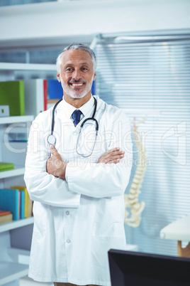 Doctor standing with arms crossed in clinic