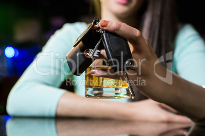 Woman holding a glass of whiskey and car keys