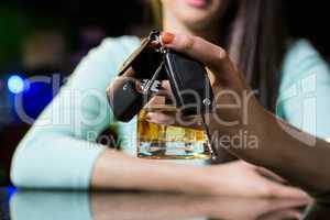 Woman holding a glass of whiskey and car keys