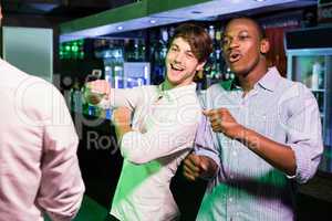 Group of men dancing near bar counter