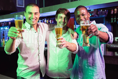 Group of men posing with glass of beer