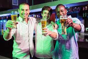 Group of men posing with glass of beer