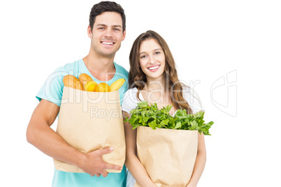 Happy couple carrying grocery bags