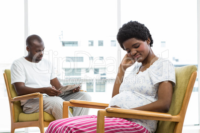 Pregnant couple sitting on chair