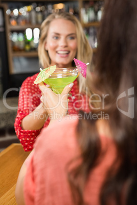 Cute friends toasting with a glass of cocktail