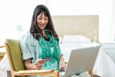 Pregnant woman shopping online on her laptop