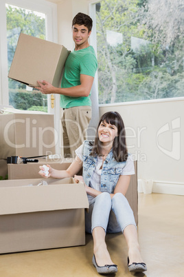 Young woman unpacking carton boxes