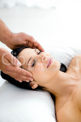 Pregnant woman receiving a head massage from masseur