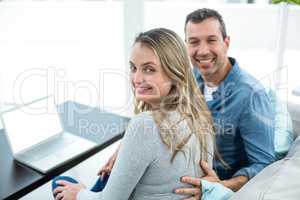 Couple using laptop in living room