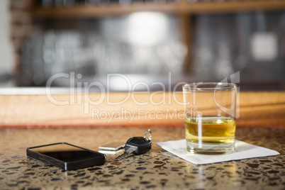 View of whiskey, smartphone and car keys