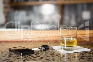 View of whiskey, smartphone and car keys