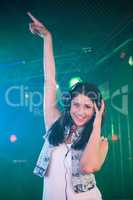 Pretty female DJ having fun while listening music on headphone