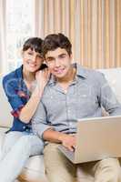 Portrait of young couple using a laptop