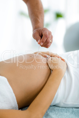 Pregnant woman receiving a spa treatment from masseur