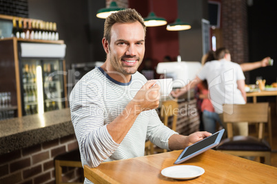 Handsome man using tablet computer and having a coffee Handsome man using tablet computer and having a coffee